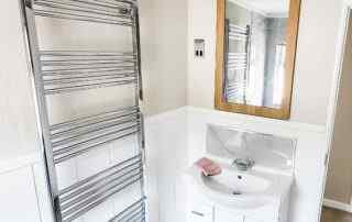 Plot 1 - Crowsheath Estate - Bathroom View - showing the sink and stainless radiator.
