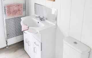 Plot 1 - Crowsheath Estate - Bathroom View - showing the sink, toilet, and stainless radiator.