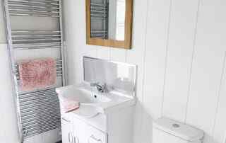 Plot 1 - Crowsheath Estate - Bathroom View - showing the sink, toilet, and stainless radiator.